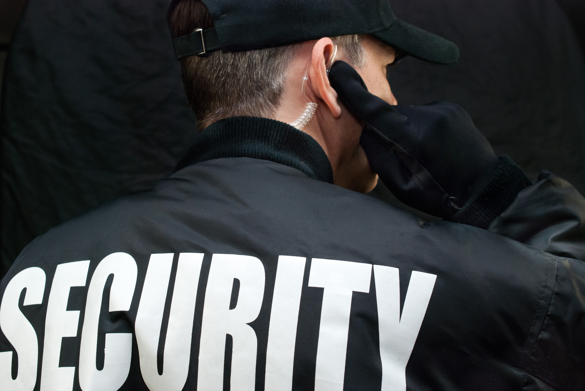 Close-up Of A Security Guard Listening To His Earpiece